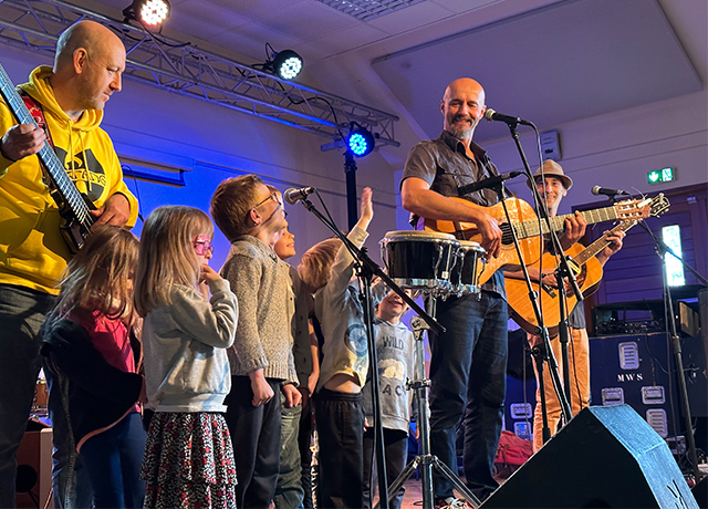 Photographie de musiciens et d'enfants sur scène